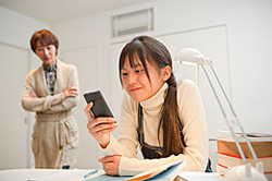 スマートフォンを使う中学生